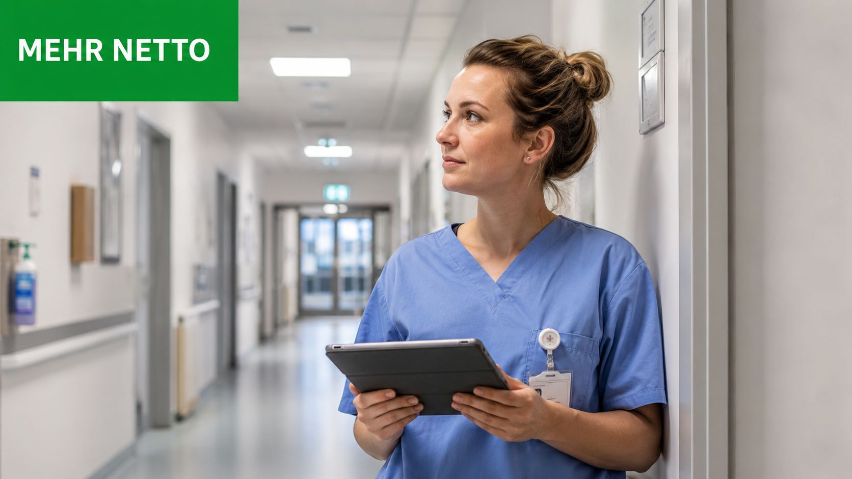 Eine junge Krankenschwester mit blauem Kasack steht auf einem Krankenhausflur und hält ein Tablet in den Händen.